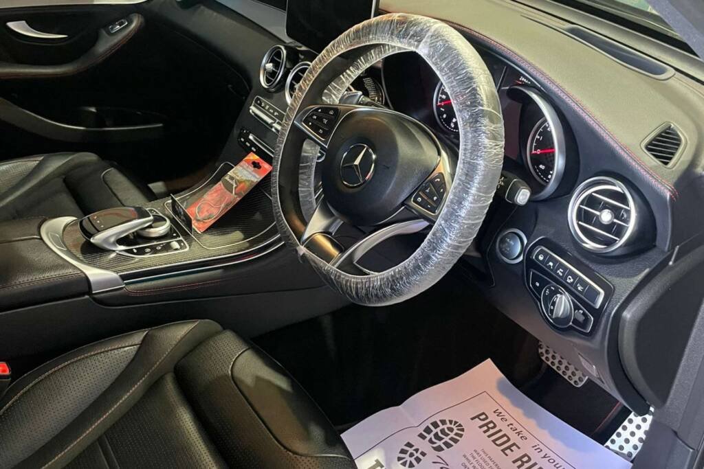 Detailed Mercedes-Benz driver cabin with leather seats, plastic-wrapped steering wheel, and floor mat