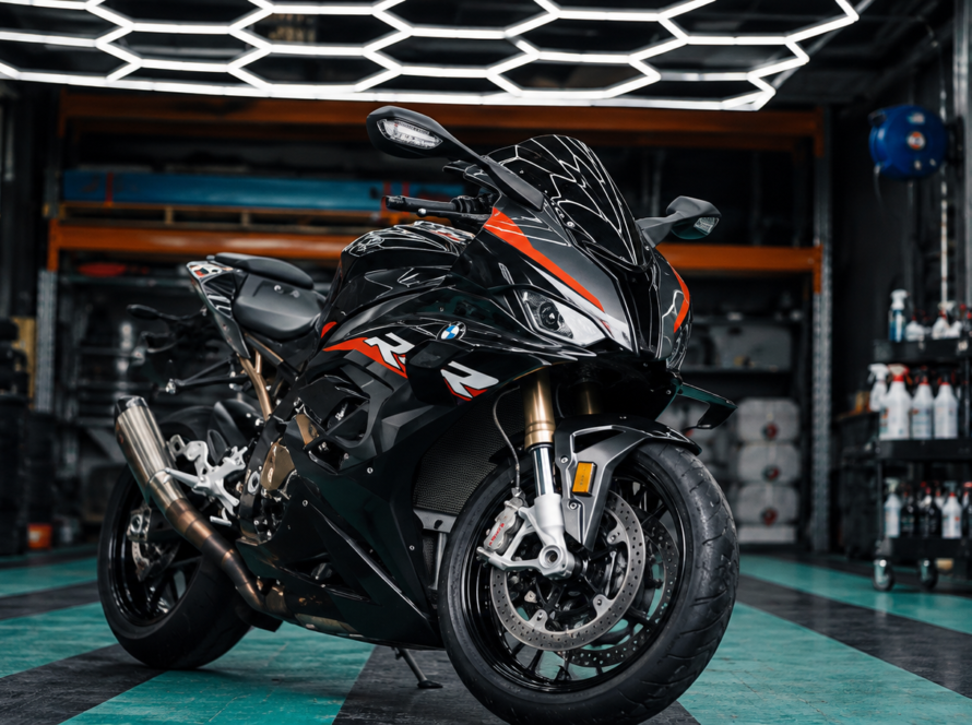 A sleek black sports motorcycle inside a professional detailing workshop in Perth, prepared for ceramic paint protection.